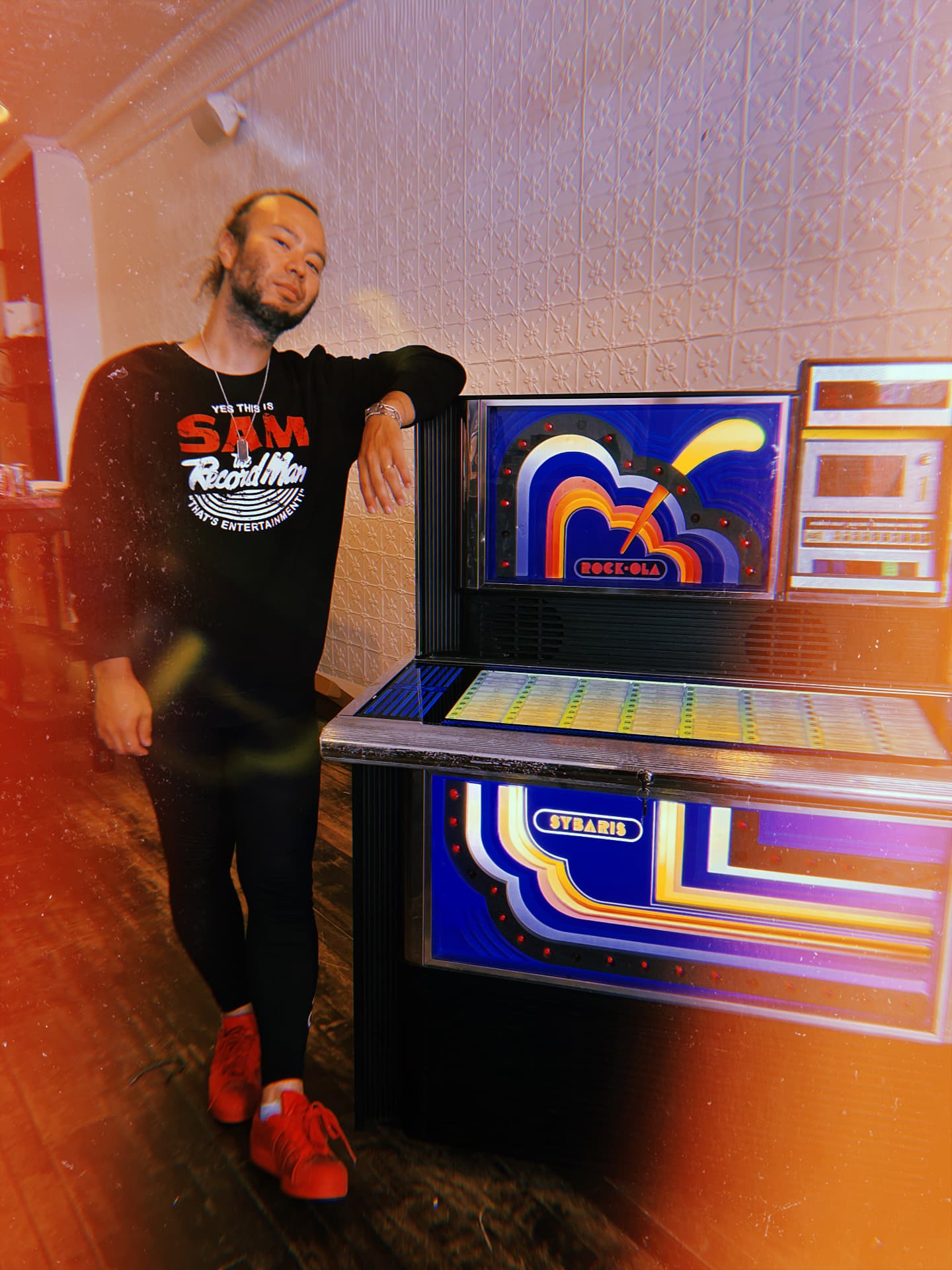 Man leaning on a vintage Rock-Ola jukebox