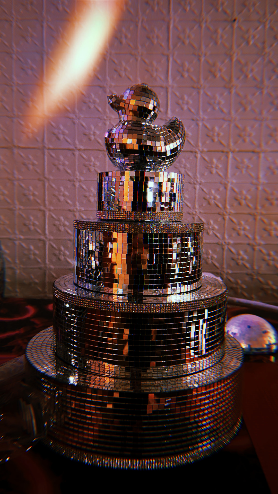 Mirrored disco-ball cake topped with a disco duck