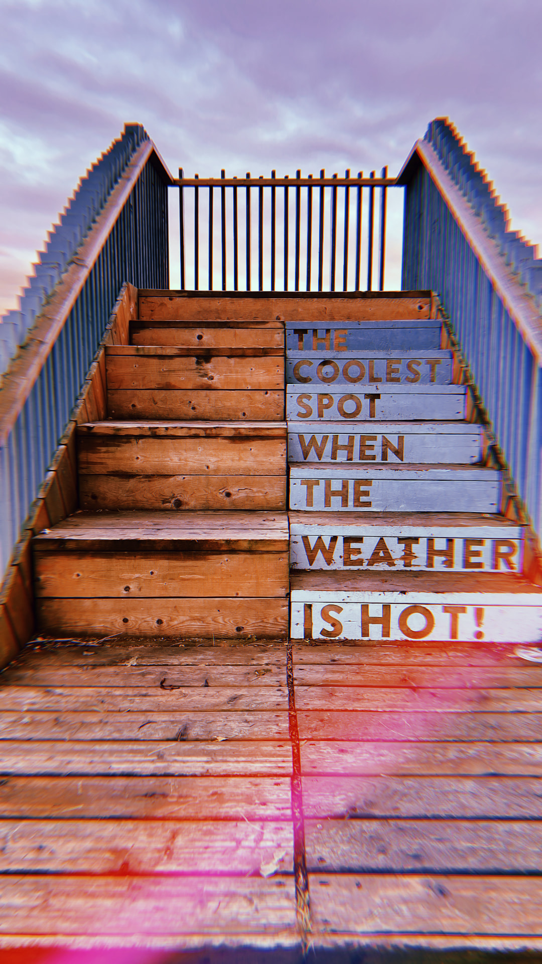 Wooden staircase with painted lettering reading The Coolest Spot When The Weather Is Hot