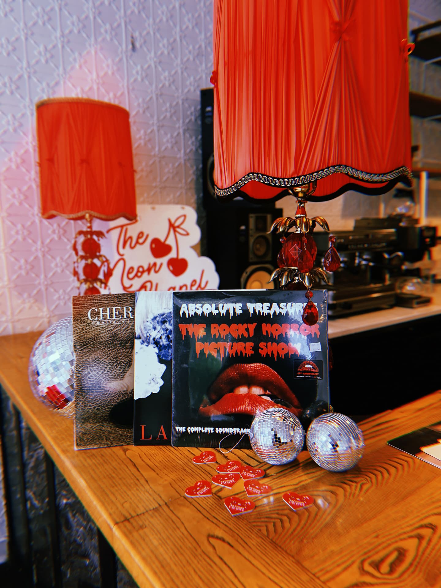 Rocky Horror Picture Show record, red lamp and mini disco balls on a wooden counter