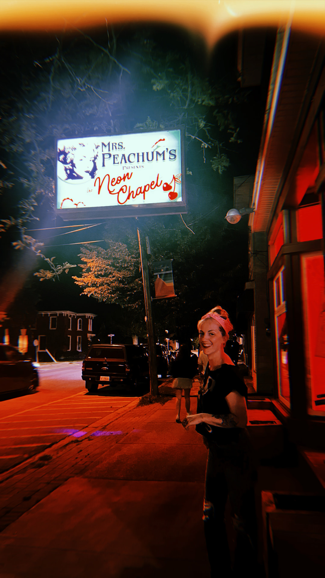 Mrs. Peachum's Neon Chapel sign glowing at night on Wellington Main Street